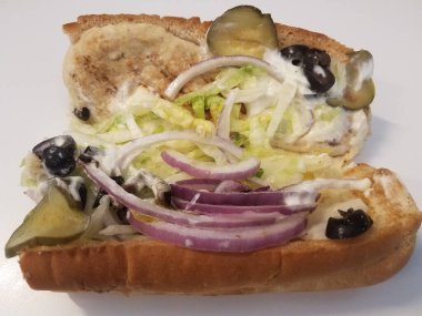 Tavuklu sandviç, soğanlı, turşulu, zeytinli ve mayonezli beyaz yüzey ya da masa