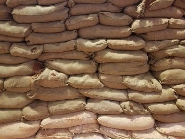 Kahverengi tuval kum torbaları üst üste yığılmış.