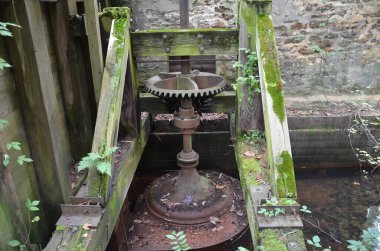 Ahşap, yosun ve taş bina ile paslı endüstriyel metal teçhizat