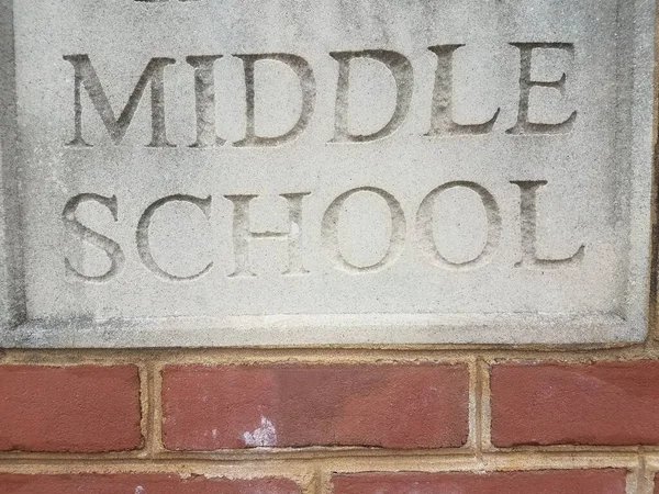 用红砖写着中学的灰色水泥标牌 — 图库照片