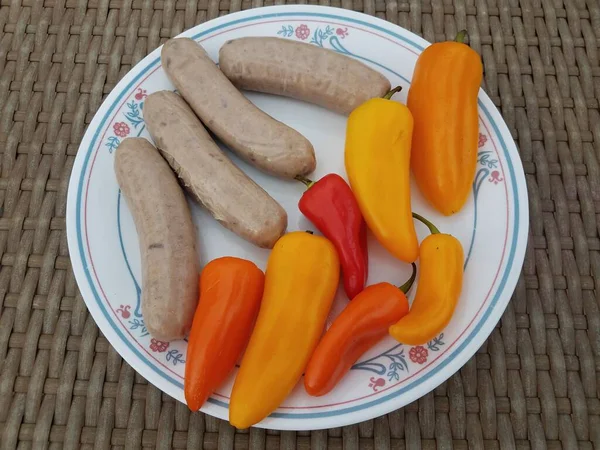 Würstchen Und Bunte Paprika Auf Weißem Teller Auf Dem Tisch — Stockfoto