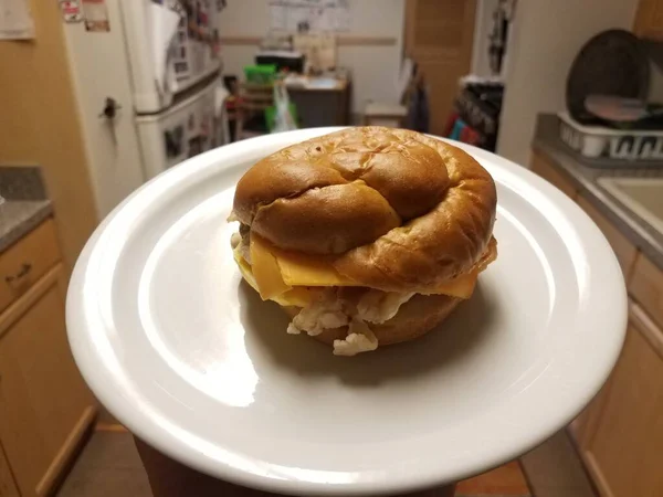 Mão Segurando Ovo Bacon Sanduíche Queijo Placa Branca Cozinha — Fotografia de Stock