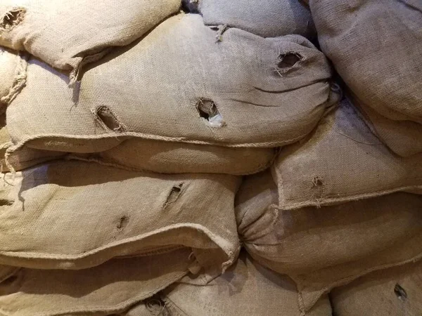 wall of brown canvas sandbags stacked up high