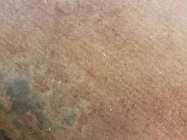 very dirty red carpet or rug with fading and black marks