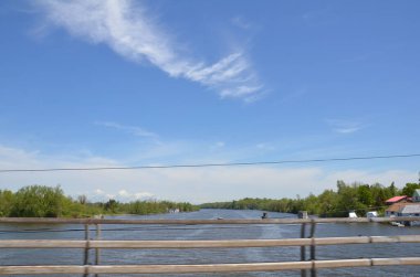Gökyüzü, köprü, korkuluk ve tel ile nehir suyu