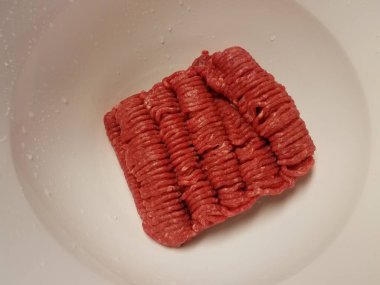 Beyaz kabın içinde çiğ kırmızı et.