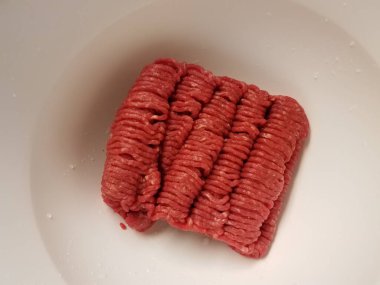 Beyaz kabın içinde çiğ kırmızı et.