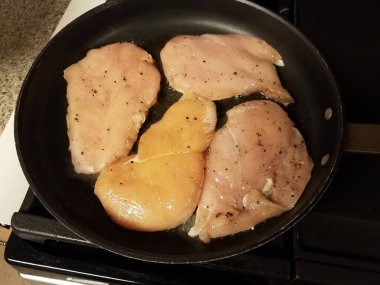 Çiğ tavuk göğsü eti kızartma tavasında yağ ile pişiriliyor.