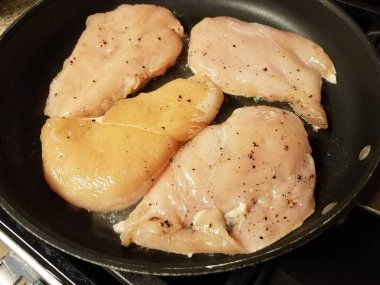 Çiğ tavuk göğsü eti kızartma tavasında yağ ile pişiriliyor.