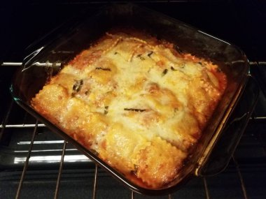 Fırında cam kabın içinde peynirli ravioli.