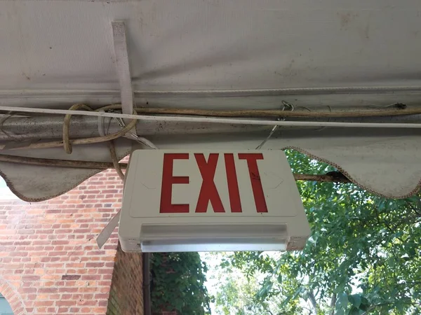 a red exit sign hanging from a tent pole