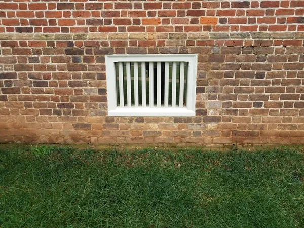 Rode Bakstenen Muur Met Wit Kelderraam Groen Gras — Stockfoto