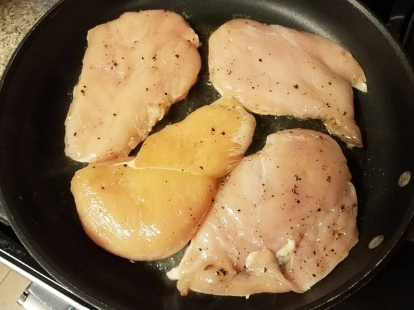 生鶏の胸肉を油でフライパンで調理 — ストック写真