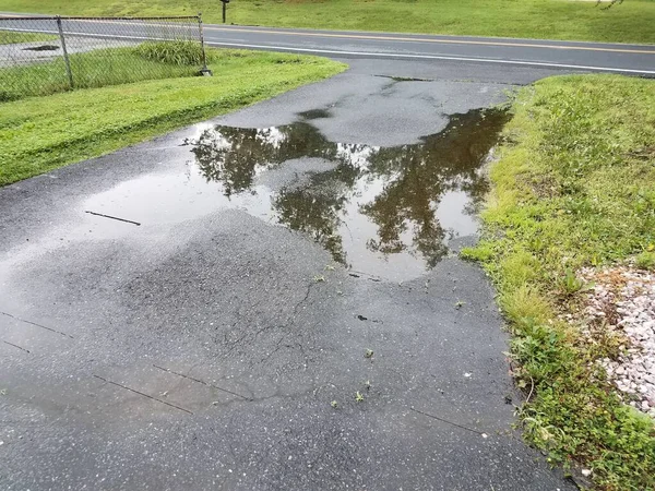 浸水したアスファルトの車道にある大きな水溜りは — ストック写真