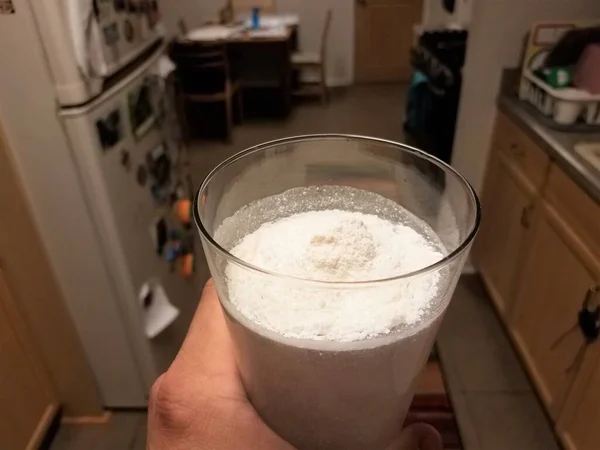 厨房里拿着一杯水和白蛋白粉 — 图库照片