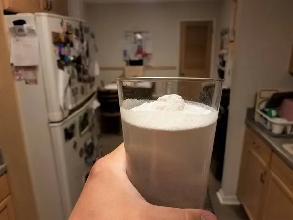 Χέρι Κρατώντας Ποτήρι Νερό Και Κιμωλία Λευκή Σκόνη Στην Κουζίνα — Φωτογραφία Αρχείου