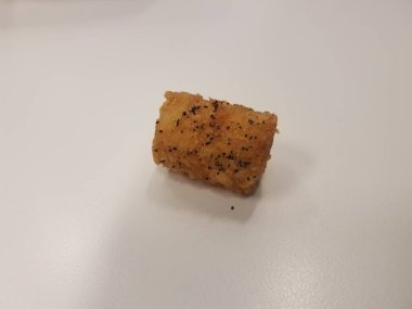 Beyaz bir yüzeyde biberli tek bir patates kızartması.