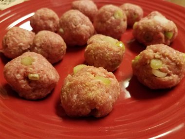 Kırmızı tabakta çiğ domuz eti ve soğanlı köfte.