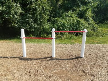 beyaz ve kırmızı metal çubuklar oyun parkında odun parçalarıyla