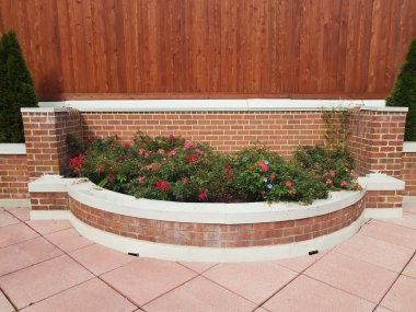 Çiçekli yeşil bitkiler, ahşap duvarlar ve kare pembe fayanslar