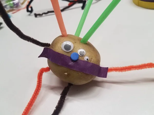 potato head with straws and pipe cleaner on table