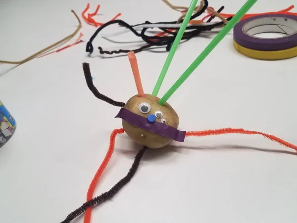 potato head with straws and pipe cleaner on table