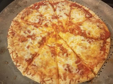 Çedar ve mozzarella peynirli pizza. Metal tepside dilimlenmiş kırmızı domates soslu.