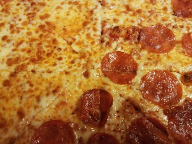 Yağlı yarım peynir yarısı pepperonili peynirli pizza dilimleri.