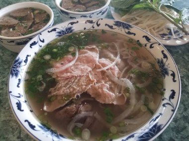 Bir kase Vietnam çorbası sığır eti, soğan ve köfte.