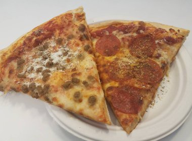 iki dilim pizza pepperoni ve sosis bir tabakta