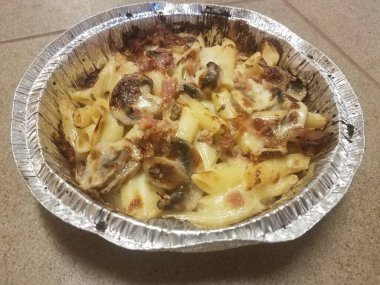 Pastırmalı makarna ve fayans zeminde folyo tabakta mantar.
