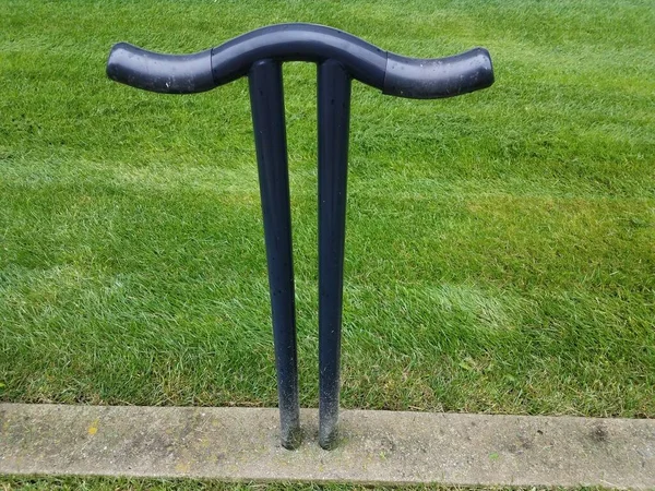 black metal bike rack in shape of the number pi