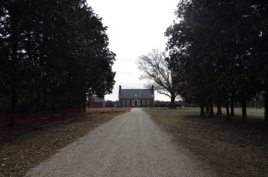 Çakıl taşı yolu ya da çimenli ve ağaçlı kırmızı tuğla eve giden yol.