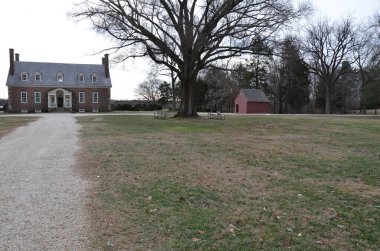 Çakıl taşı yolu ya da çimenli ve ağaçlı kırmızı tuğla eve giden yol.
