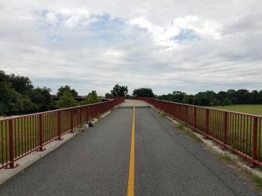 Kırmızı metal parmaklıklı bisiklet ve yürüyüş yolu