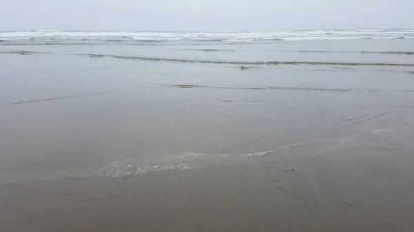 湿った砂と波がビーチの干渉パターンに交差し — ストック写真