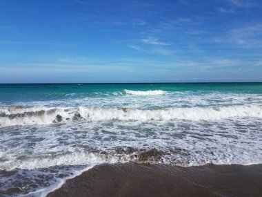 Okyanus dalgaları ve kumsaldaki ıslak kumlar