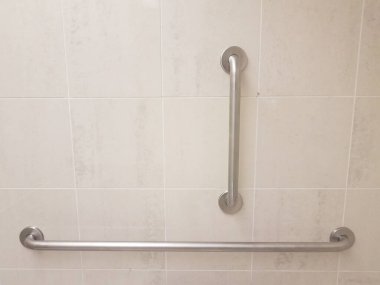 Bronzlaşmış banyo duvarında iki metal parmaklık.