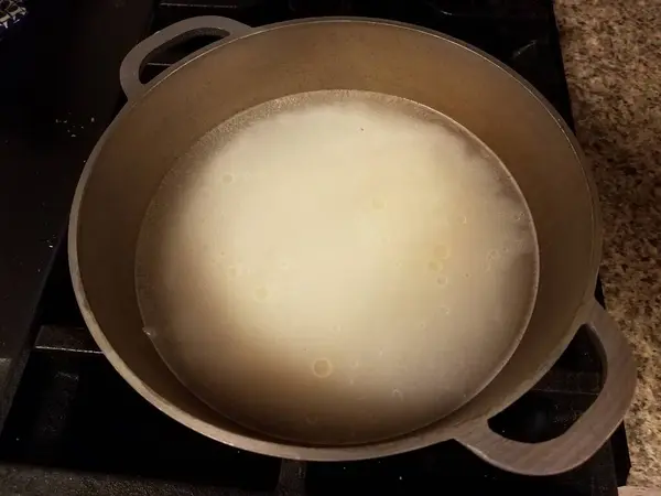 水と油を入れたストーブの上の金属鍋のご飯茶碗 — ストック写真