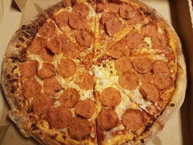 Büyük bir pepperonili et ve dilimlenmiş peynirli pizza.