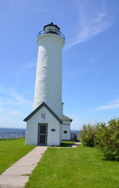 tall white lighthouse building or structure and blue sky Tibbetts Point