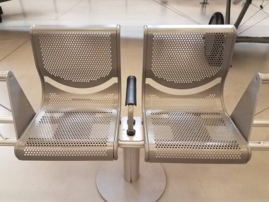 İki parlak metal sandalye ya da delikli koltuklar.