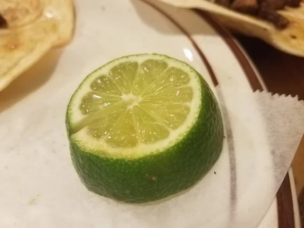 Een Sappige Groene Limoen Een Witte Plaat — Stockfoto