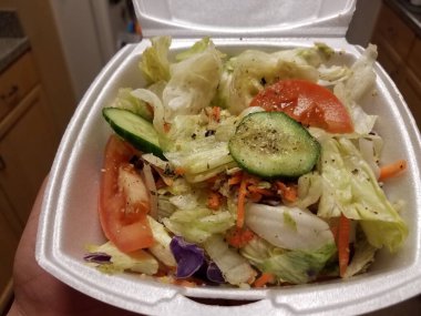 Salatalı ve domatesli, köpüklü bir kap salata.