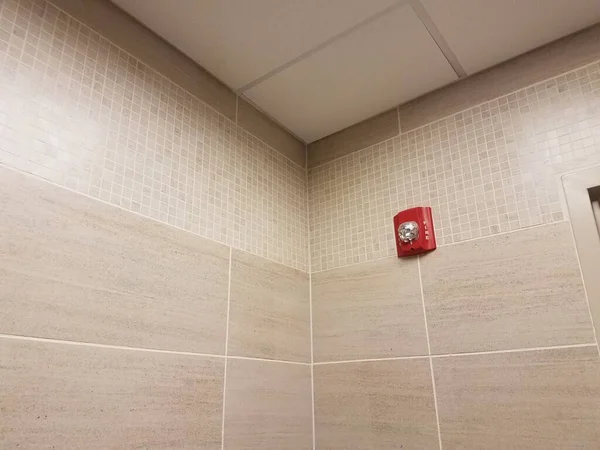 バスルームにはグレーのタイルと赤い火災警報器があります — ストック写真