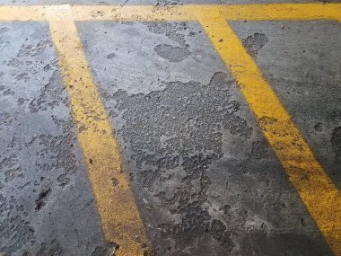 Gri, pürüzlü, eskimiş ya da yıpranmış çimento ya da sarı çizgilerle kaplı zemin