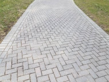 gri dikdörtgen tuğla yolu veya iz ve yeşil çimen