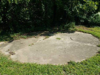 Yeşil çimenli gri bir çimento dairesi.