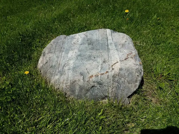 青草或草坪上的灰色岩石或石头或巨石 — 图库照片