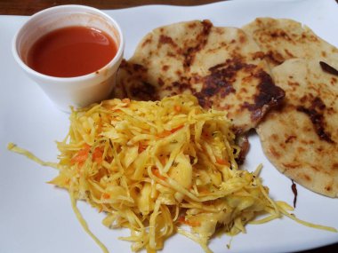 Pupusa ya da lahana ve domates sosuyla doldurulmuş peynirli kızarmış tortilla.